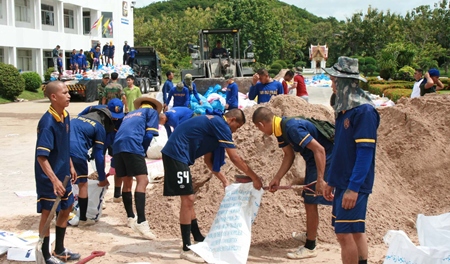 Enlisted navy men fill sandbags destined to try and stop the surge of flood waters from the north.